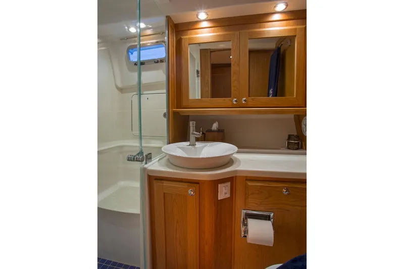  Yacht Photos Pics Luxurious bathroom in 2025 Sabre 45 Salon Express yacht with wooden cabinetry and modern fixtures.