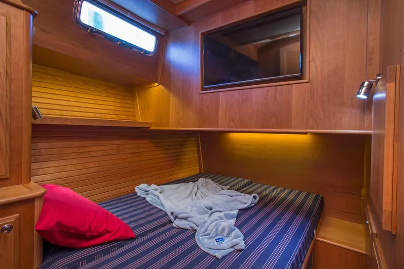  Yacht Photos Pics Cozy cabin interior of 2025 Sabre 45 Salon Express with bed and wooden paneling.