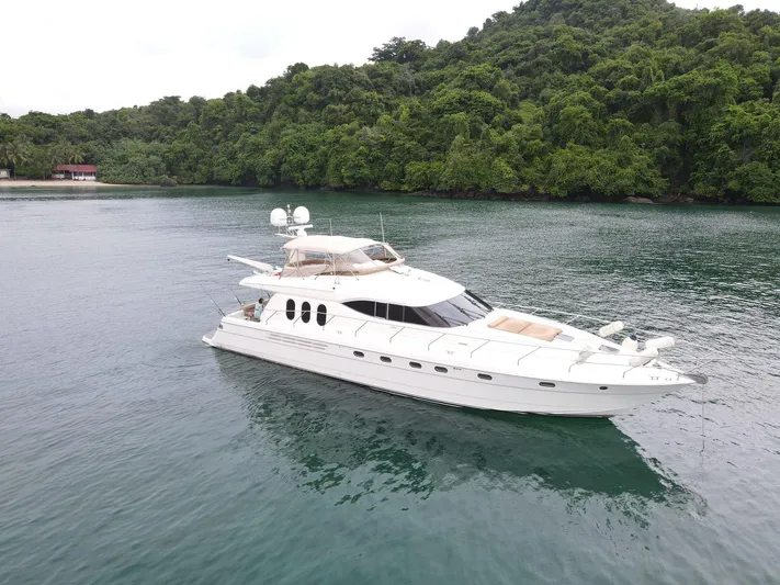  Yacht Photos Pics 2003 Viking Princess 68 Sport Cruiser yacht on serene water near lush green forest.