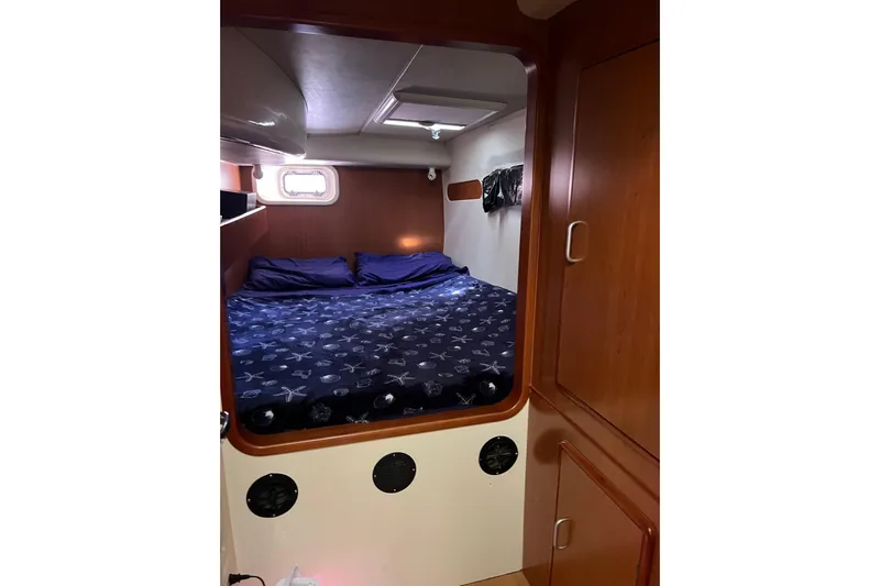  Yacht Photos Pics Cozy cabin interior of 2010 Leopard 40 yacht with bed and wooden cabinetry.