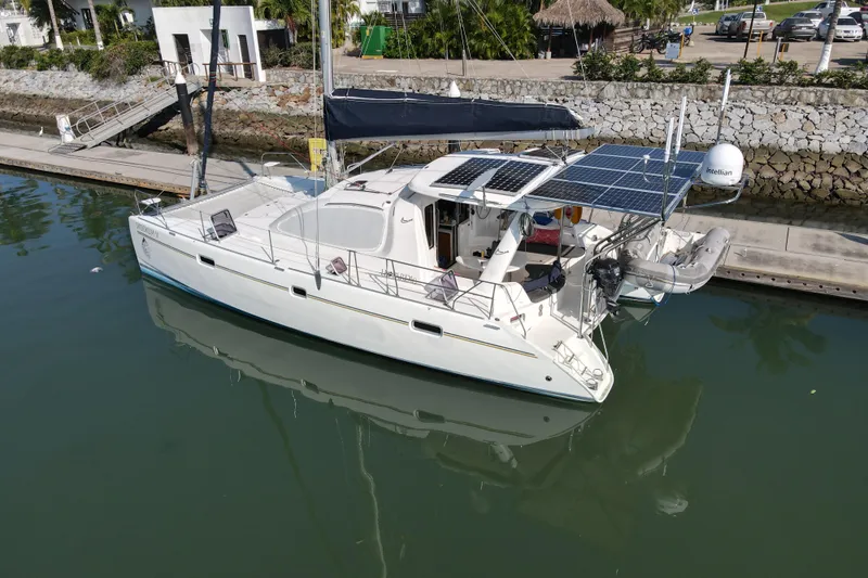  Yacht Photos Pics 2010 Leopard 40 catamaran docked, featuring solar panels and a dinghy.