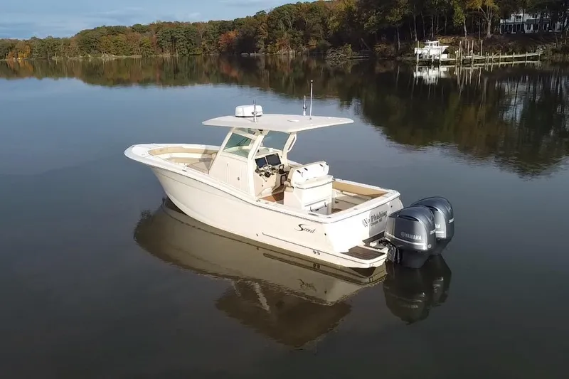  Yacht Photos Pics 2016 Scout 300 LXF boat on calm lake with wooded shoreline.