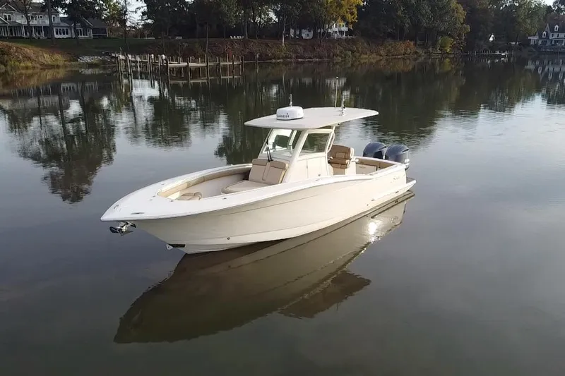  Yacht Photos Pics 2016 Scout 300 LXF boat on calm water, surrounded by trees and houses.