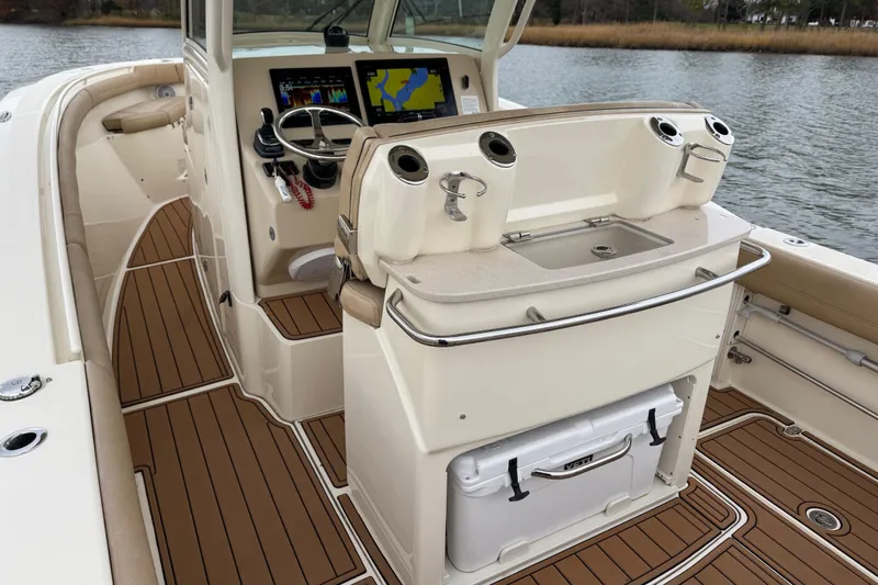 Yacht Photos Pics 2016 Scout 300 LXF boat interior with helm, navigation screens, and teak flooring.
