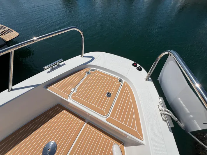 San #155 In Stock Yacht Photos Pics Nimbus T9 2024 boat deck with wood finish and stainless steel railing.