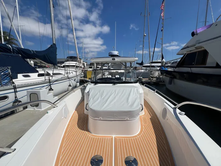 San #155 In Stock Yacht Photos Pics Nimbus T9 2024 boat docked at marina, surrounded by sailboats under a clear blue sky.
