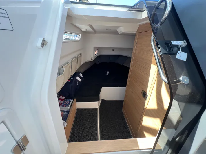 San #155 In Stock Yacht Photos Pics 2024 Nimbus T9 boat cabin interior with cozy bed and wooden accents.