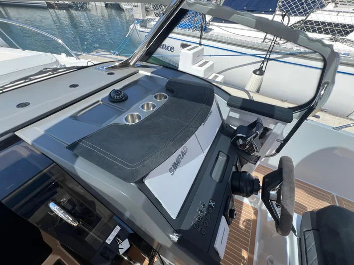 San #155 In Stock Yacht Photos Pics 2024 Nimbus T9 boat dashboard with modern controls and steering wheel, docked at marina.