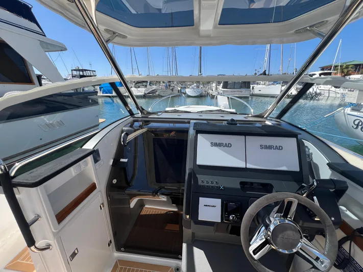 San #155 In Stock Yacht Photos Pics Nimbus T9 2024 boat cockpit with modern navigation system, docked at marina.