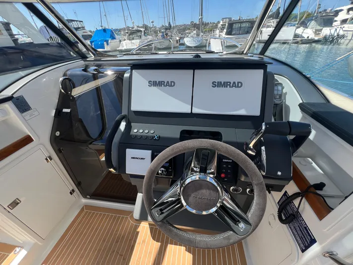 San #155 In Stock Yacht Photos Pics 2024 Nimbus T9 boat cockpit with dual Simrad displays and steering wheel.