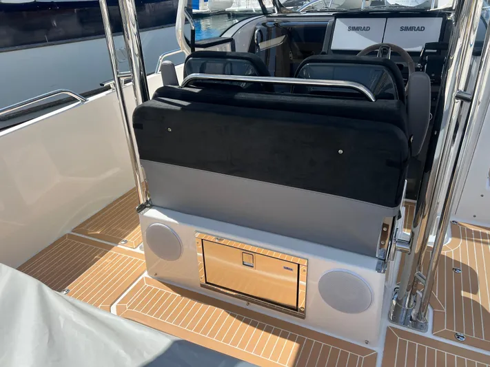 San #155 In Stock Yacht Photos Pics 2024 Nimbus T9 boat interior with seating and Simrad navigation system.