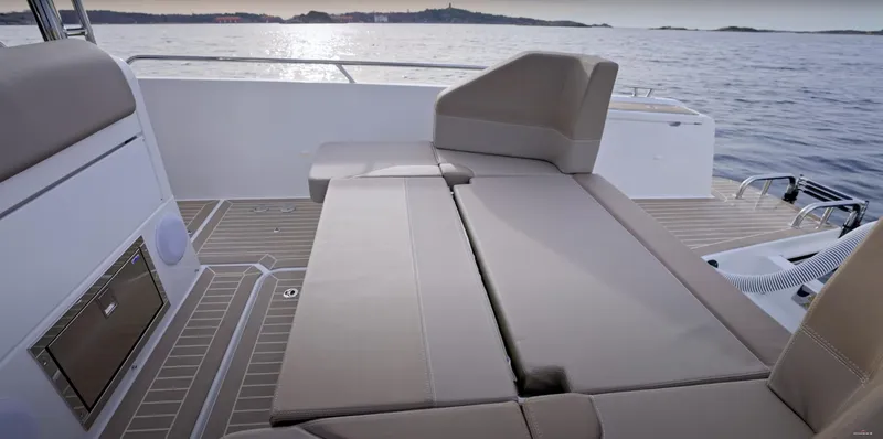 San #155 In Stock Yacht Photos Pics 2024 Nimbus T9 boat interior with beige seating, overlooking calm waters.