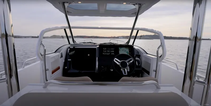 San #155 In Stock Yacht Photos Pics 2024 Nimbus T9 boat cockpit with modern steering and digital display on calm water.