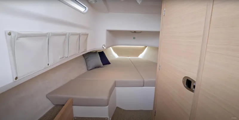 San #155 In Stock Yacht Photos Pics 2024 Nimbus T9 cabin interior with cozy bed and storage compartments.