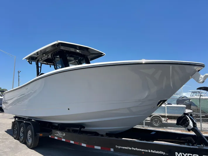  Yacht Photos Pics 2025 Robalo R300 Center Console boat on trailer, displayed outdoors under clear blue sky.