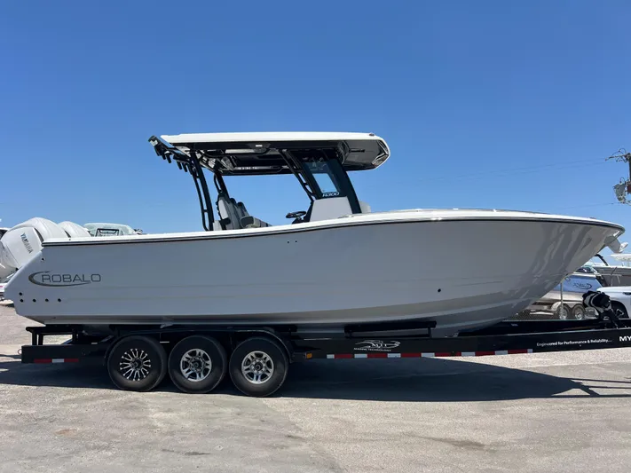  Yacht Photos Pics 2025 Robalo R300 Center Console boat on a trailer under clear blue sky.