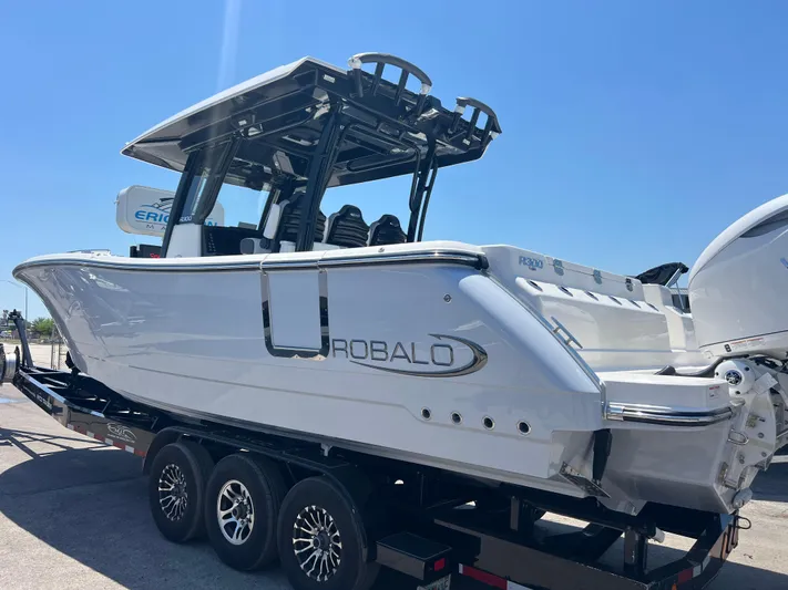  Yacht Photos Pics 2025 Robalo R300 Center Console boat on trailer, side view under clear blue sky.