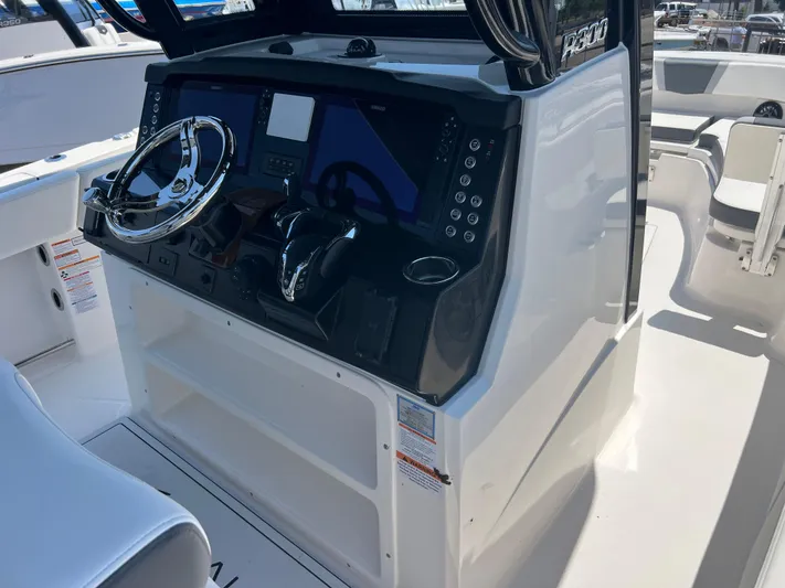  Yacht Photos Pics 2025 Robalo R300 Center Console boat dashboard with steering wheel and controls.
