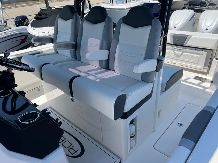  Yacht Photos Pics 2025 Robalo R300 Center Console boat with three cushioned seats and modern helm.