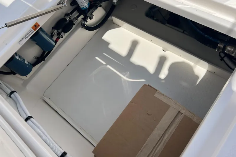  Yacht Photos Pics 2025 Robalo R300 Center Console storage compartment with cardboard box and visible wiring.