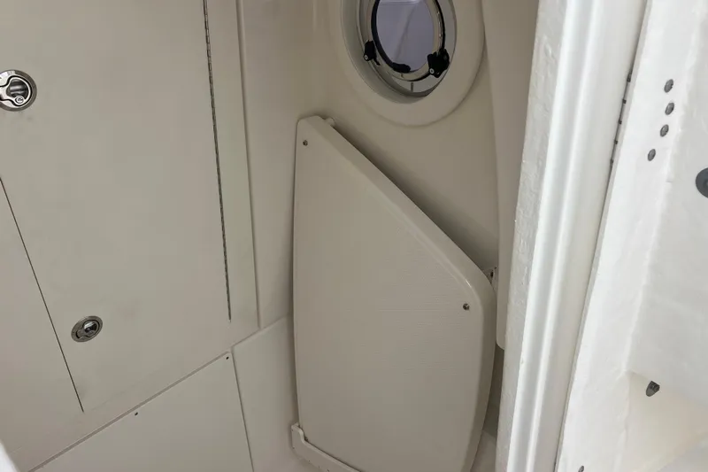  Yacht Photos Pics 2025 Robalo R300 Center Console interior with porthole and storage compartment.