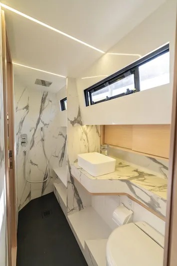  Yacht Photos Pics Luxurious bathroom in 2025 Blu Martin Yachts WALK AROUND 46, featuring marble accents and modern fixtures.