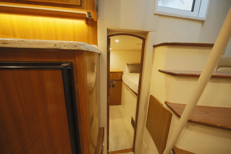 Brown Eyed Girl Yacht Photos Pics Interior of 2014 Viking 42 Sport Tower yacht, featuring wooden cabinetry and cozy sleeping quarters.