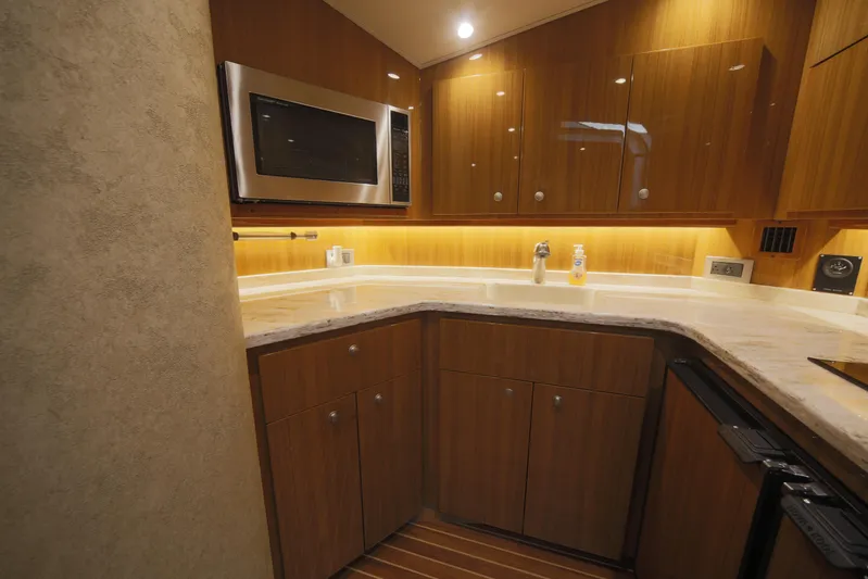 Brown Eyed Girl Yacht Photos Pics 2014 Viking 42 Sport Tower kitchen with wood cabinets, microwave, and under-cabinet lighting.