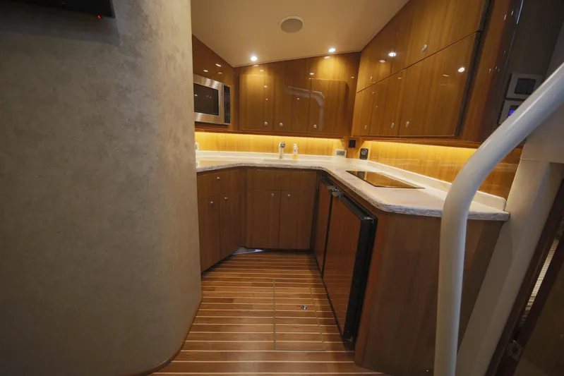 Brown Eyed Girl Yacht Photos Pics 2014 Viking 42 Sport Tower kitchen with wood cabinets, modern appliances, and ambient lighting.