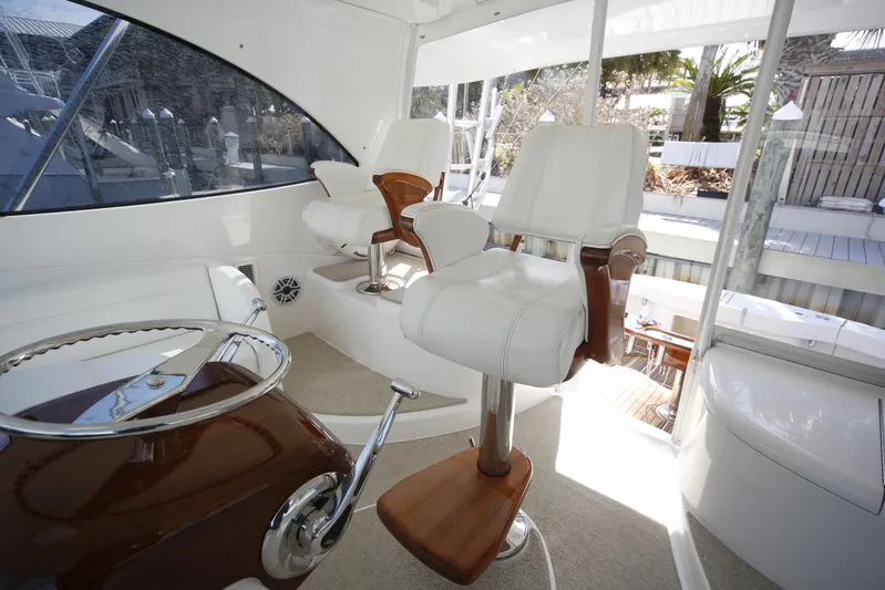 Brown Eyed Girl Yacht Photos Pics Interior of 2014 Viking 42 Sport Tower with white captain chairs and steering wheel.