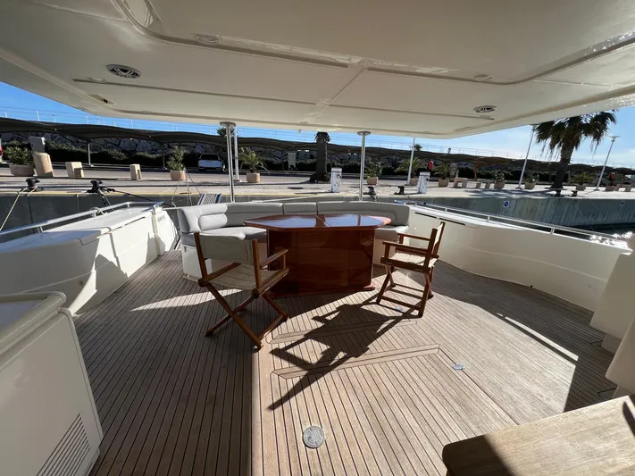  Yacht Photos Pics Outdoor deck of 2002 Ferretti Yachts 810 with wooden chairs and table.