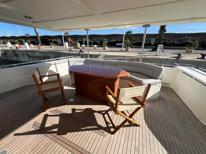  Yacht Photos Pics Luxurious 2002 Ferretti Yachts 810 deck with elegant seating and wooden table.