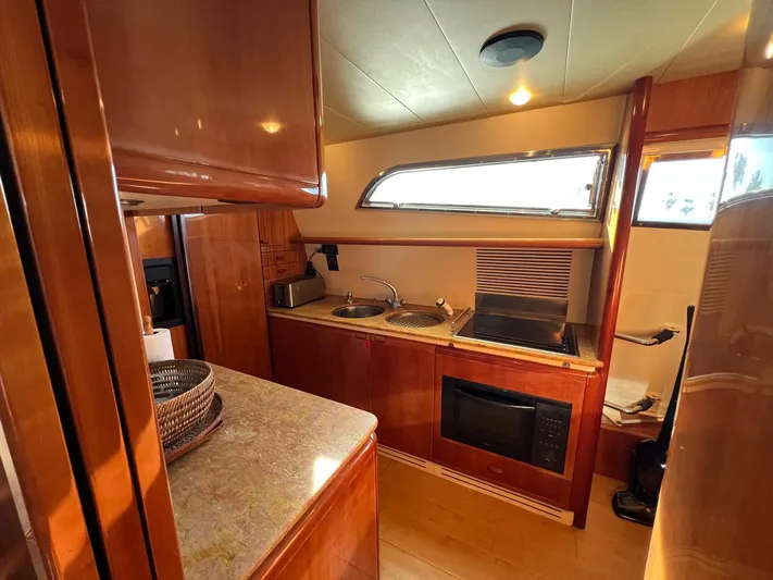  Yacht Photos Pics Luxurious kitchen interior of 2002 Ferretti Yachts 810 with modern amenities and wooden finishes.