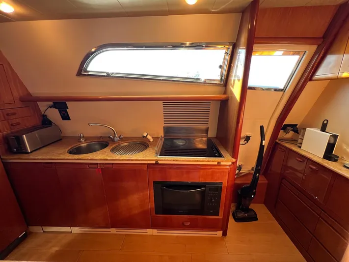  Yacht Photos Pics Luxurious kitchen area in a 2002 Ferretti Yachts 810, featuring modern appliances and wood cabinetry.