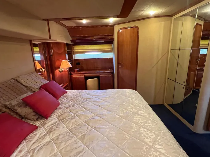  Yacht Photos Pics Luxurious bedroom interior of 2002 Ferretti Yachts 810 with elegant wood finishes.