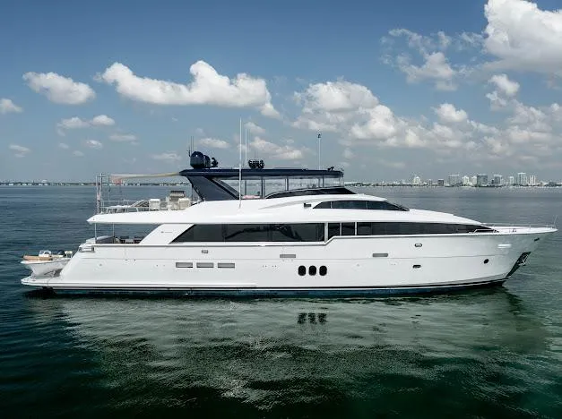 Living The Experience Yacht Photos Pics 2015 Hatteras 100 Raised Pilothouse luxury yacht on calm waters under a blue sky.