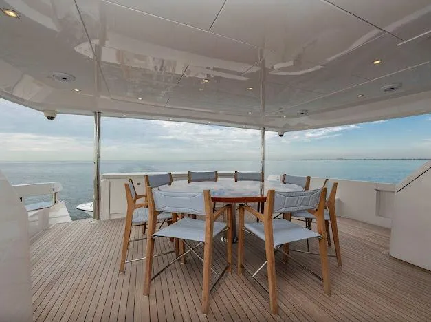 Living The Experience Yacht Photos Pics Outdoor dining area on 2015 Hatteras 100 Raised Pilothouse yacht with ocean view.