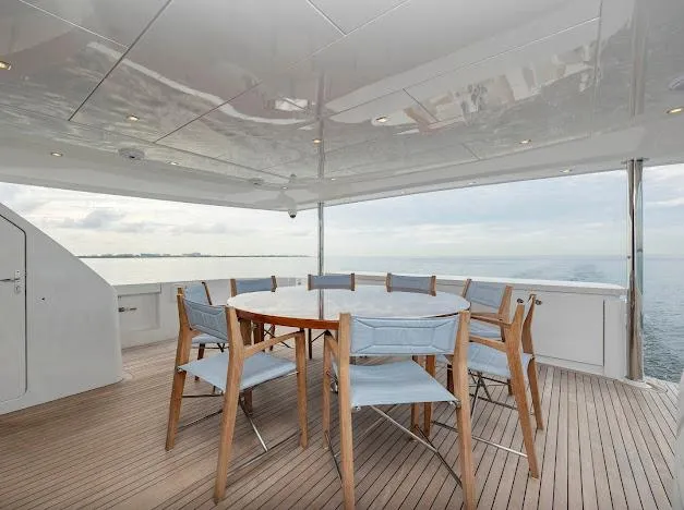 Living The Experience Yacht Photos Pics Outdoor dining area on 2015 Hatteras 100 Raised Pilothouse yacht with ocean view.