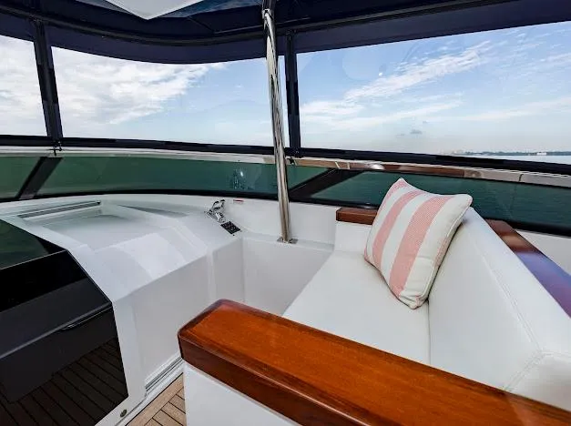 Living The Experience Yacht Photos Pics Interior of 2015 Hatteras 100 Raised Pilothouse yacht with white seating and striped pillow.