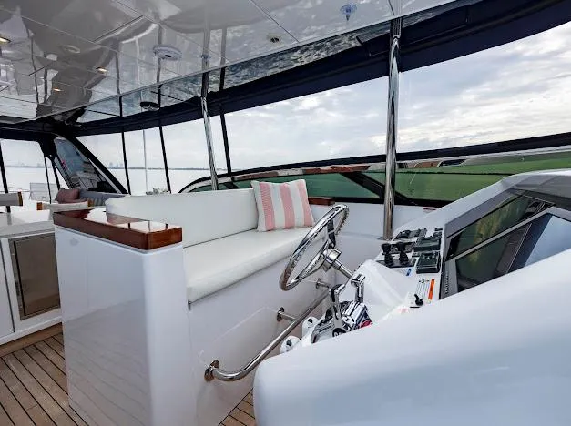 Living The Experience Yacht Photos Pics Helm station of 2015 Hatteras 100 Raised Pilothouse yacht with white seating and modern controls.