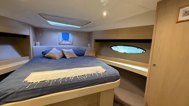  Yacht Photos Pics Luxurious cabin interior of 2016 Princess 56 yacht with cozy bed and porthole window.