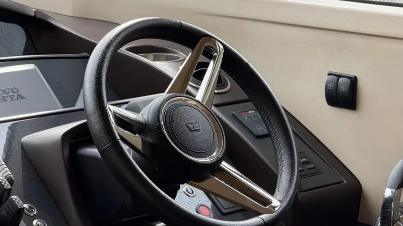  Yacht Photos Pics Steering wheel of a 2016 Princess 56 yacht, featuring modern controls and Volvo Penta branding.