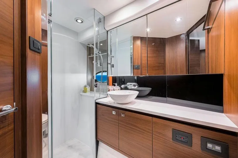  Yacht Photos Pics Luxurious bathroom in 2017 Princess 56 yacht with modern fixtures and wooden cabinetry.