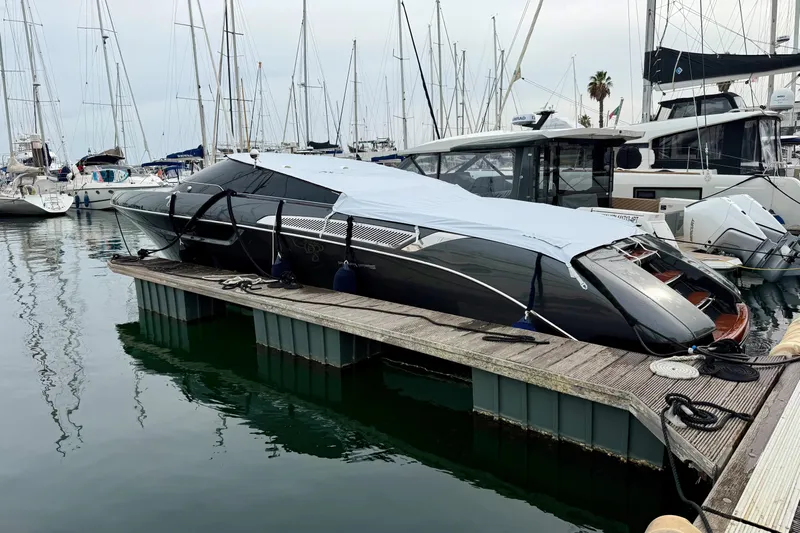  Yacht Photos Pics 2025 Riva Rivamare yacht docked at marina, covered and secured, surrounded by other boats.