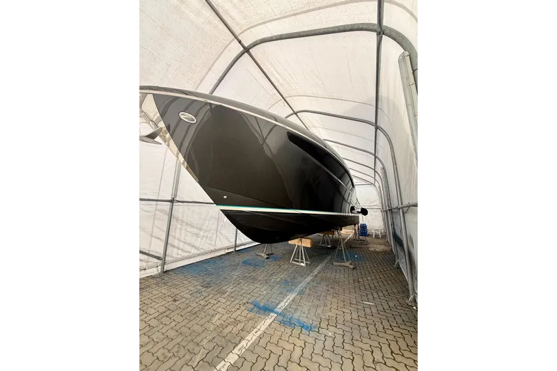  Yacht Photos Pics 2025 Riva Rivamare yacht in storage, sleek black hull, sheltered in a covered area.