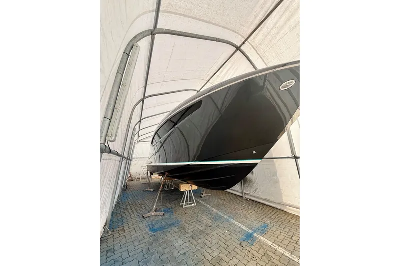  Yacht Photos Pics 2025 Riva Rivamare boat in storage, showcasing sleek black hull design.