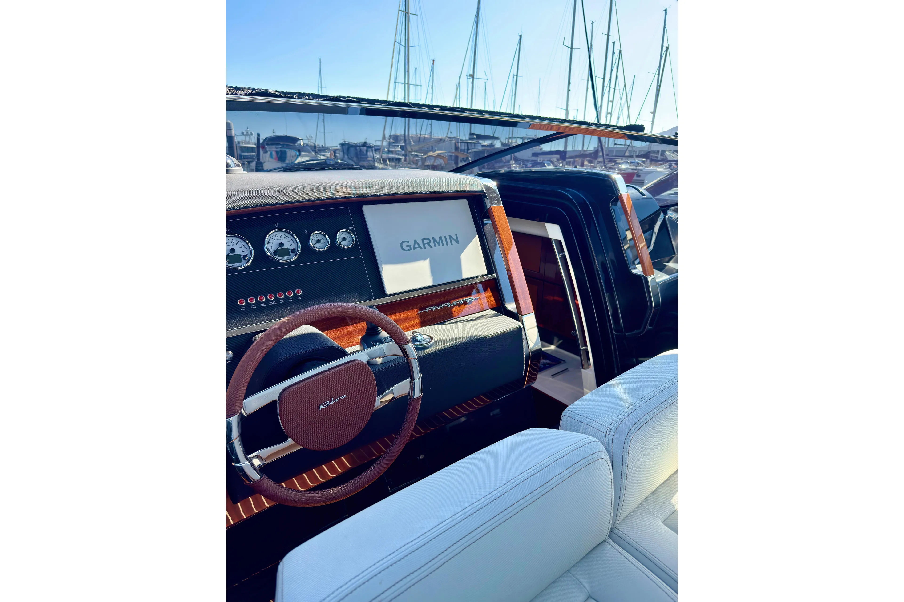  Yacht Photos Pics 2025 Riva Rivamare yacht dashboard with Garmin navigation, luxurious interior, and marina background.