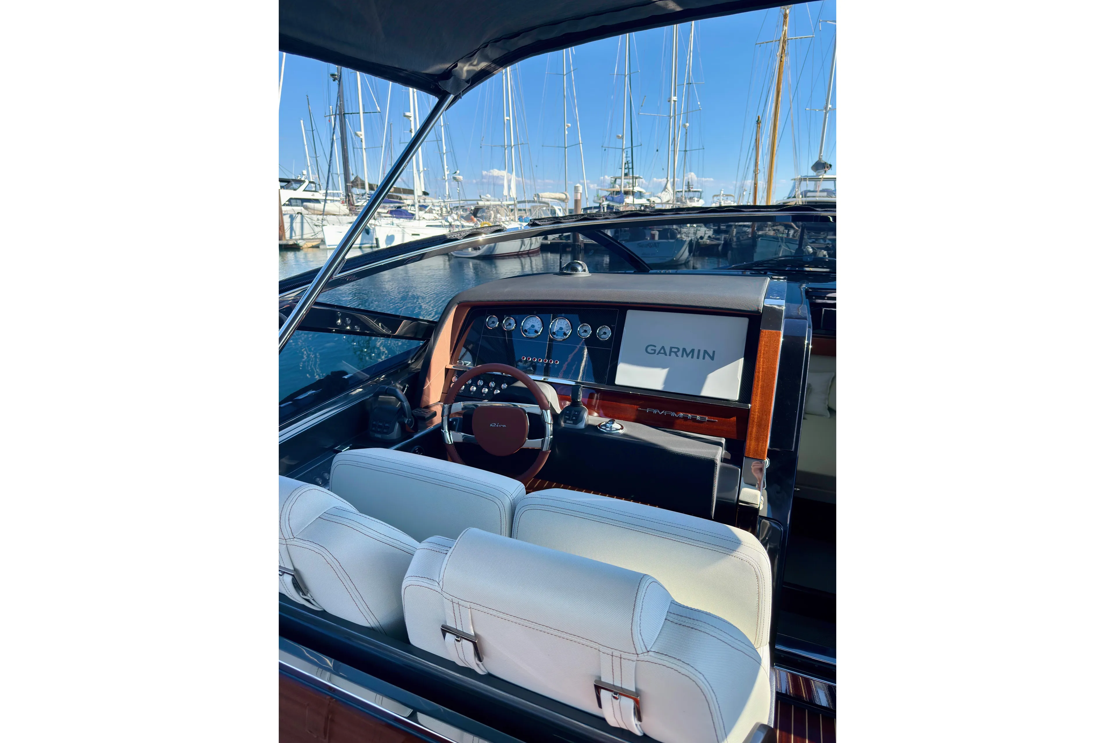  Yacht Photos Pics 2025 Riva Rivamare yacht cockpit with Garmin navigation, luxurious seating, and marina view.
