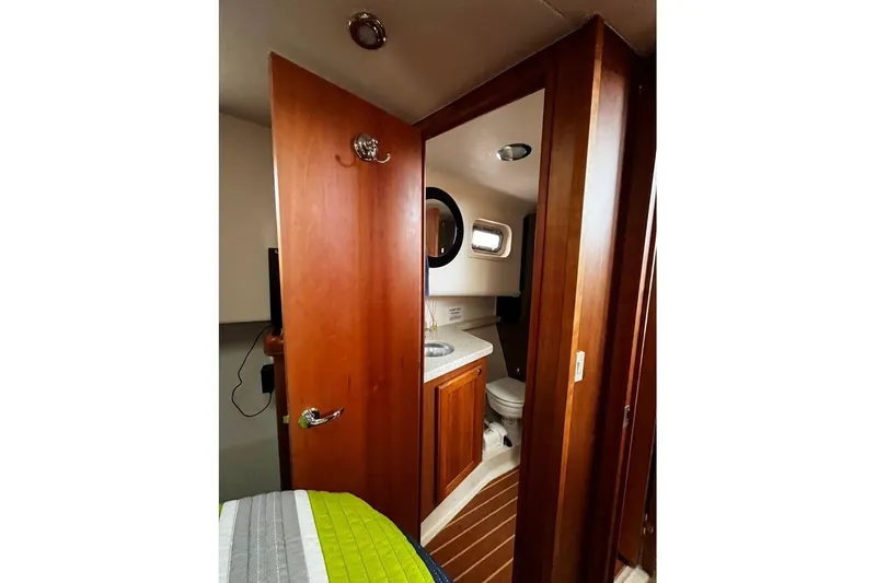  Yacht Photos Pics 2006 Mainship 34 Trawler bathroom with wooden cabinetry and compact design.