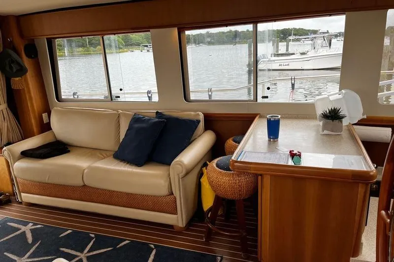  Yacht Photos Pics Interior of 2006 Mainship 34 Trawler with sofa, table, and marina view.